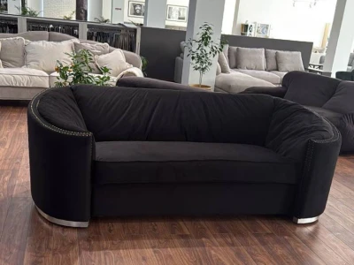 Диван-софа вигнутої форми з монолітною спинкою та хромованою металевою основою