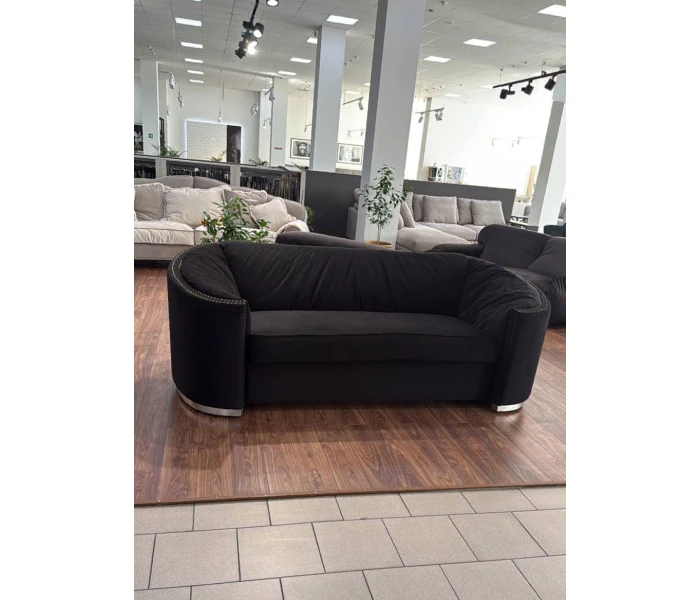 Диван-софа вигнутої форми з монолітною спинкою та хромованою металевою основою