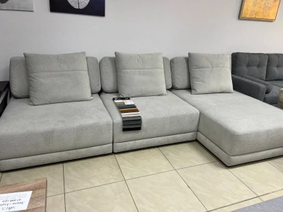 Светло-серый диван-трансформер без подлокотников.