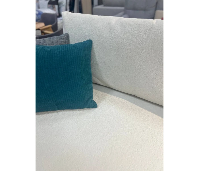 Светлый низкий диван с удлиненной секцией и мягкими подушками