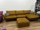 Горчичный угловой диван с большим плетеным пуфом