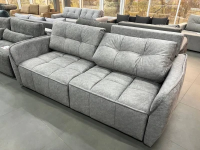 Сірий диван з глибокою посадкою та об'ємною стьобаною поверхнею