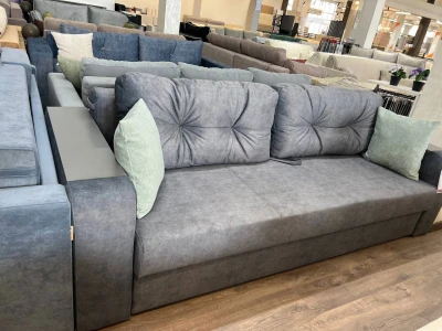 Димчасто-сірий диван з декоративними м’ятними подушками та вбудованою боковою нішею