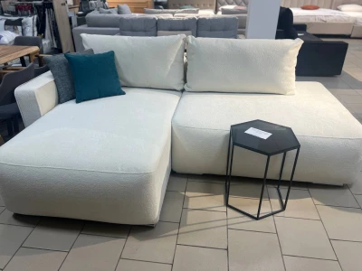 Светлый низкий диван с удлиненной секцией и мягкими подушками