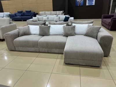 Бежевий вельветовий диван L-подібної форми з об'ємними підлокітниками