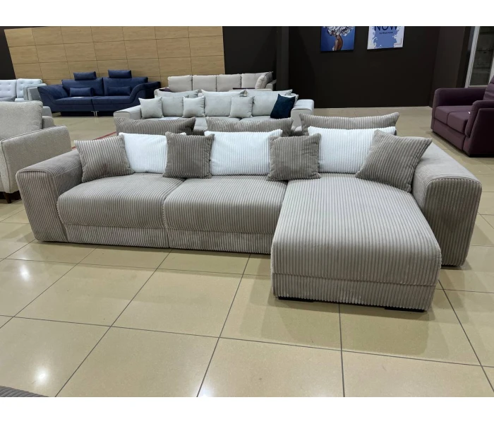 Бежевий вельветовий диван L-подібної форми з об'ємними підлокітниками