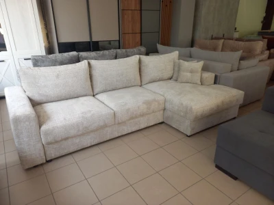 Світлий кутовий диван з м'якими подушками