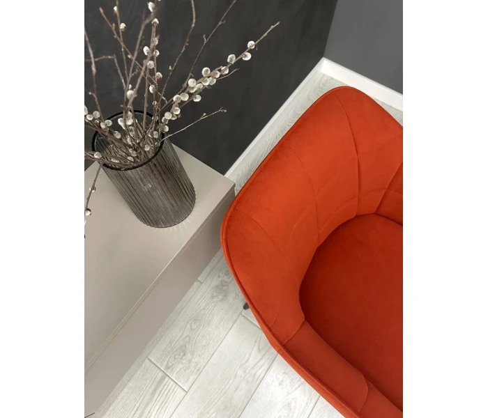 Оранжевое мягкое кресло на тонких металлических ножках