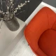 Оранжевое мягкое кресло на тонких металлических ножках