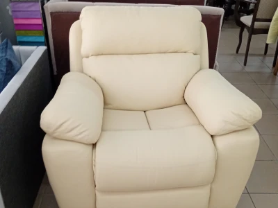Крісло-реклайнер молочного кольору зі шкіряною оббивкою