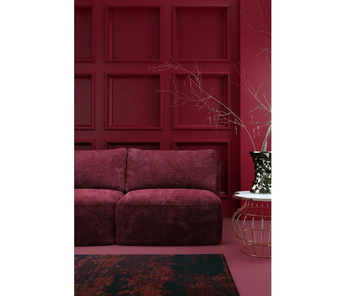 Диван у бордовій оббивці без підлокітників.
