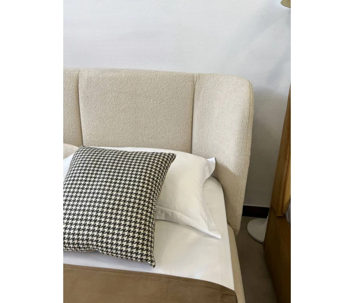 Двоспальне ліжко в тканині букле молочного кольору на високих металевих ніжках