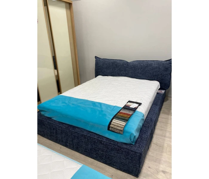 Двоспальне ліжко глибокого синього кольору з м'яким об’ємним узголів'ям-подушкою