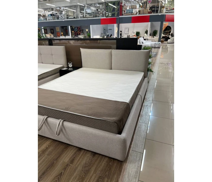 Двоспальне ліжко бежевого кольору з тонким узголів'ям