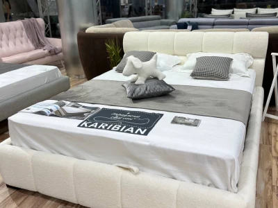 М'яке двоспальне ліжко з оббивкою букле та об'ємним сегментованим узголів'ям