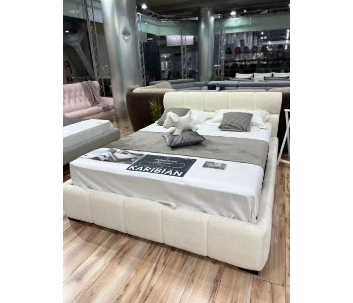 М'яке двоспальне ліжко з оббивкою букле та об'ємним сегментованим узголів'ям