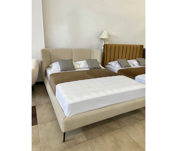 Двоспальне ліжко в тканині букле молочного кольору на високих металевих ніжках