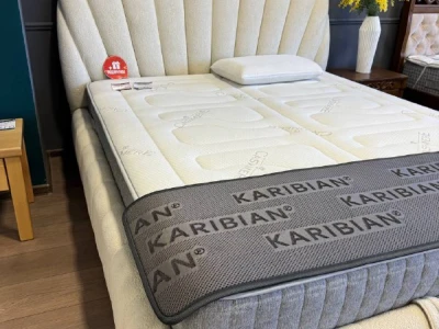 Ліжко-мушля світлого кольору з вертикальною прострочкою на узголів'ї