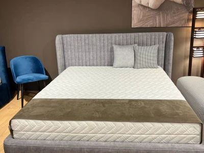 Двоспальне ліжко з високим вертикально прошитим узголів’ям та боковими бортами-вушками