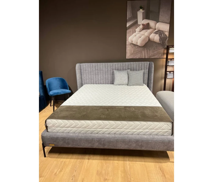 Двуспальная кровать с высоким вертикально прошитым изголовьем и боковыми бортиками-ушками