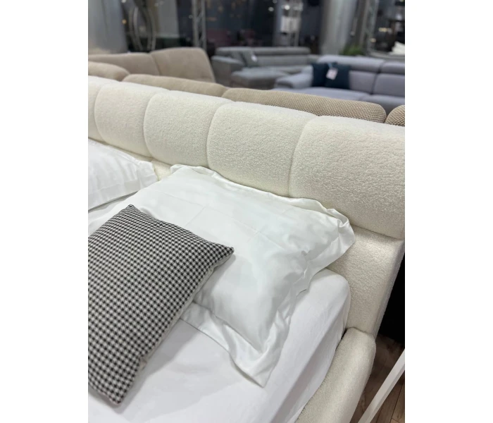 М'яке двоспальне ліжко з оббивкою букле та об'ємним сегментованим узголів'ям