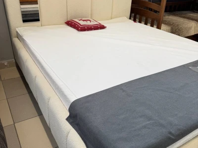 М'яке ліжко з об'ємною оббивкою розділене на вертикальні секції