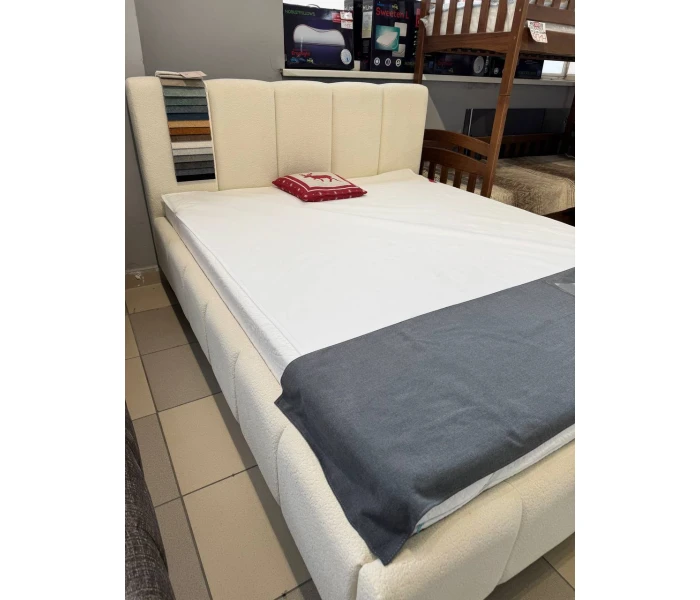 М'яке ліжко з об'ємною оббивкою розділене на вертикальні секції