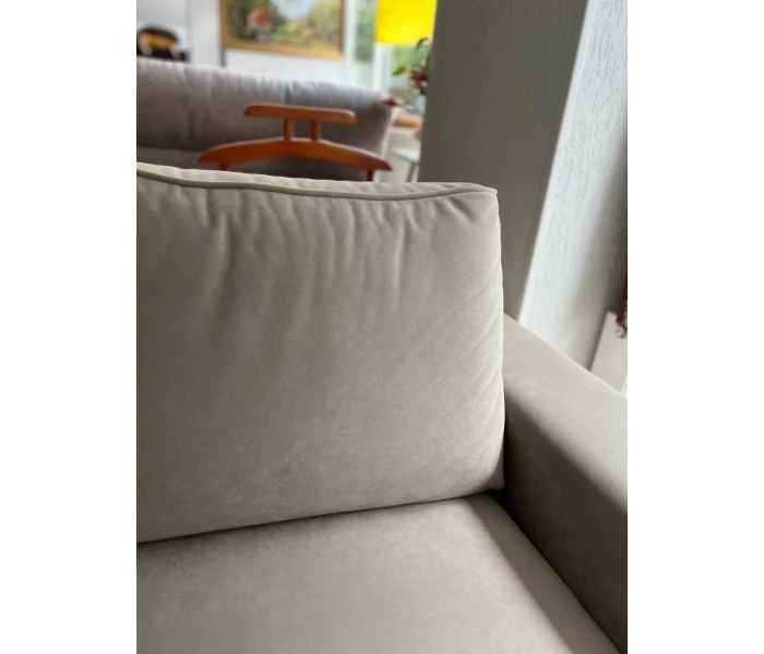 Кутова софа бежевого кольору на чорних металевих ніжках