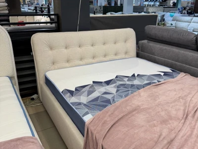 М’яке двоспальне ліжко в кремовому велюрі з об’ємним стьобаним узголів’ям