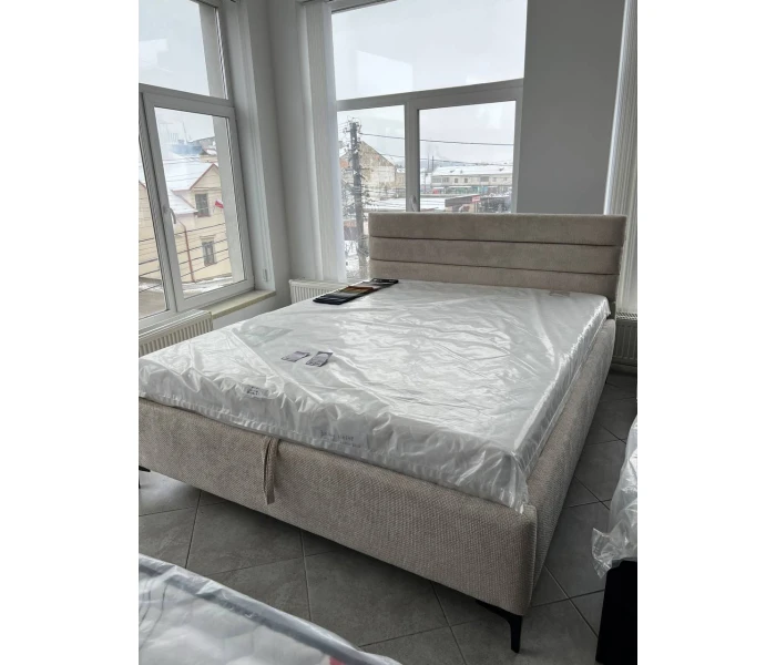 Сучасне ліжко на металевих ніжках з бежевою оббивкою