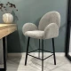 Барний стілець сірого кольору з округлою спинкою.